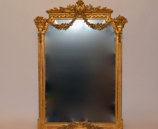 Lot 125: 19th cent Louis XVI gold leaf bevelled mirror with finely ornated top.(small acc.) H129 x W90cm.