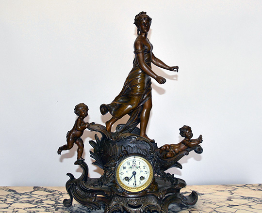 Lot 126: Turn c bronze wash spelter mantel clock with puttis sailing with young woman. H52xW36cm.