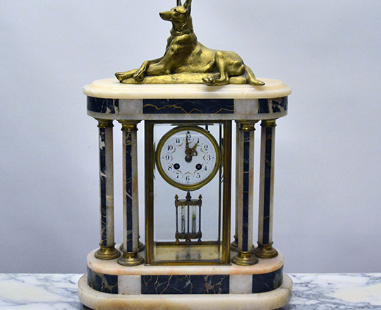 Lot 129: Large Art Deco marble and glass cage clock with gilt bronze dog resting on top. H56xW38cm.