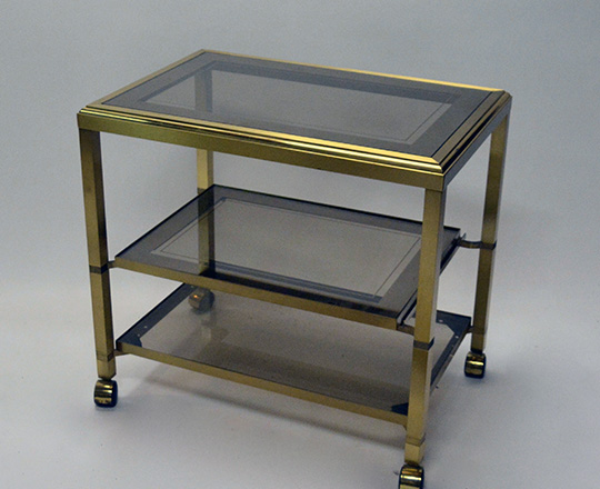 Lot 341: 70's / 80's smoked glass top three stage polished bras, bar cart on wheels.