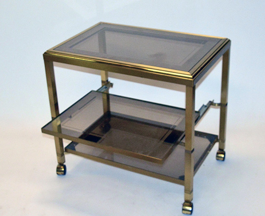 Lot 341_1: 70's / 80's smoked glass top three stage polished bras, bar cart on wheels.