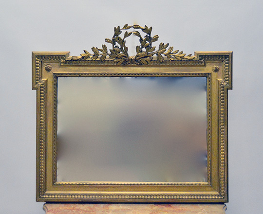 Lot 356: 19th cent unusal shape gold leaf mirror with laurel ornated pediment. H70 x W79cm.