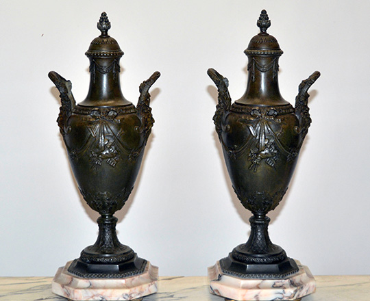 Lot 367: Pair 19th cent bronze wash lided spelter vases, each side decorated with man's faceby the handles. H 46cm (+ clock).