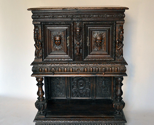 Lot 405: 17th cent well restored two stage oak cabinet on a console base with finely carved faces on top section. H139xW101xD57cm.