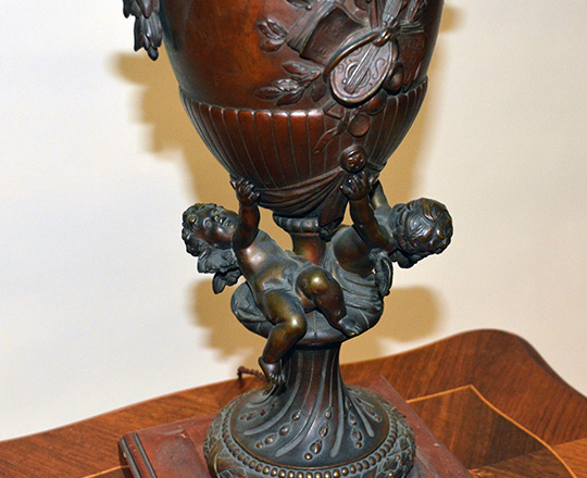 Lot 492_1: Large 19th cent bronze table lamp with two puttis supporting vase with arts attributes decor. H 62cm.