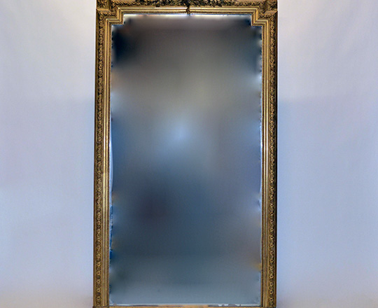 Lot 568: Tall 19th cent Louis XVI gold leaf mirror with rich ornated top. H199 x W110cm. (scratches on mirror).