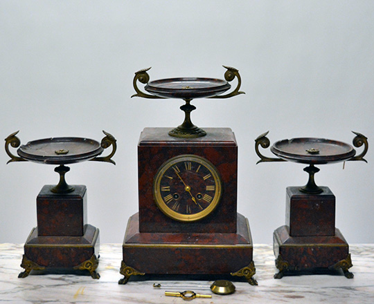 Lot 584_2: 19th c Nap.lll red marble mantle clock topped with a dish and a pair of cassolettes with repair on dishes.
