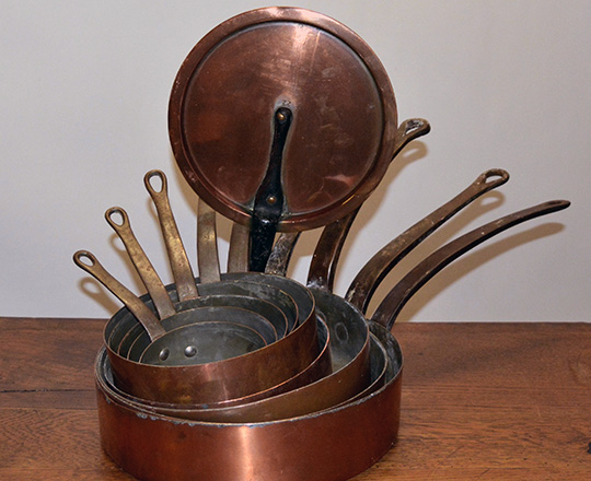 Lot 97: Set of nine graduated copper pans with one lid. Max dia.30cm.